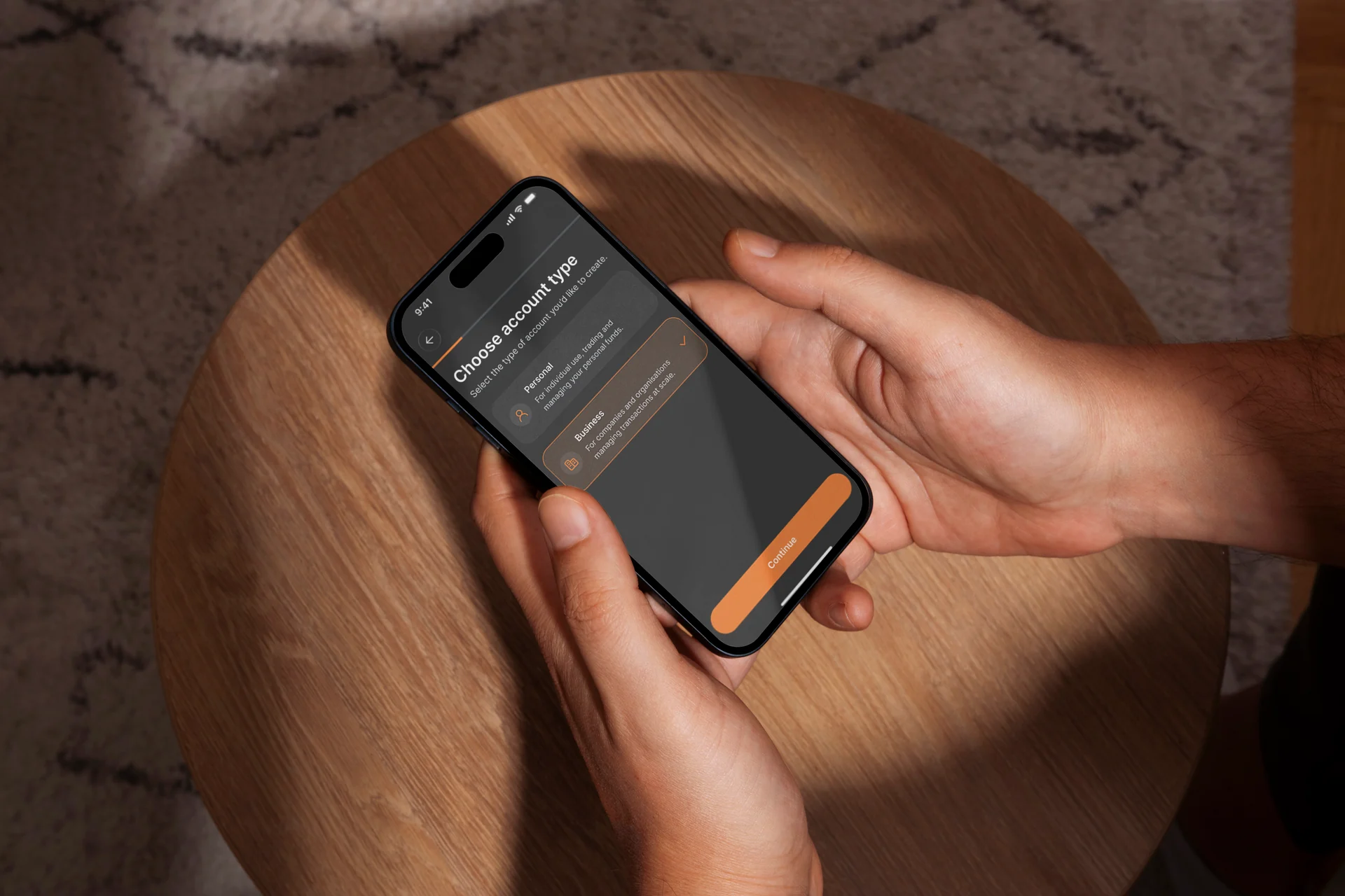Hands holding a phone showing the app